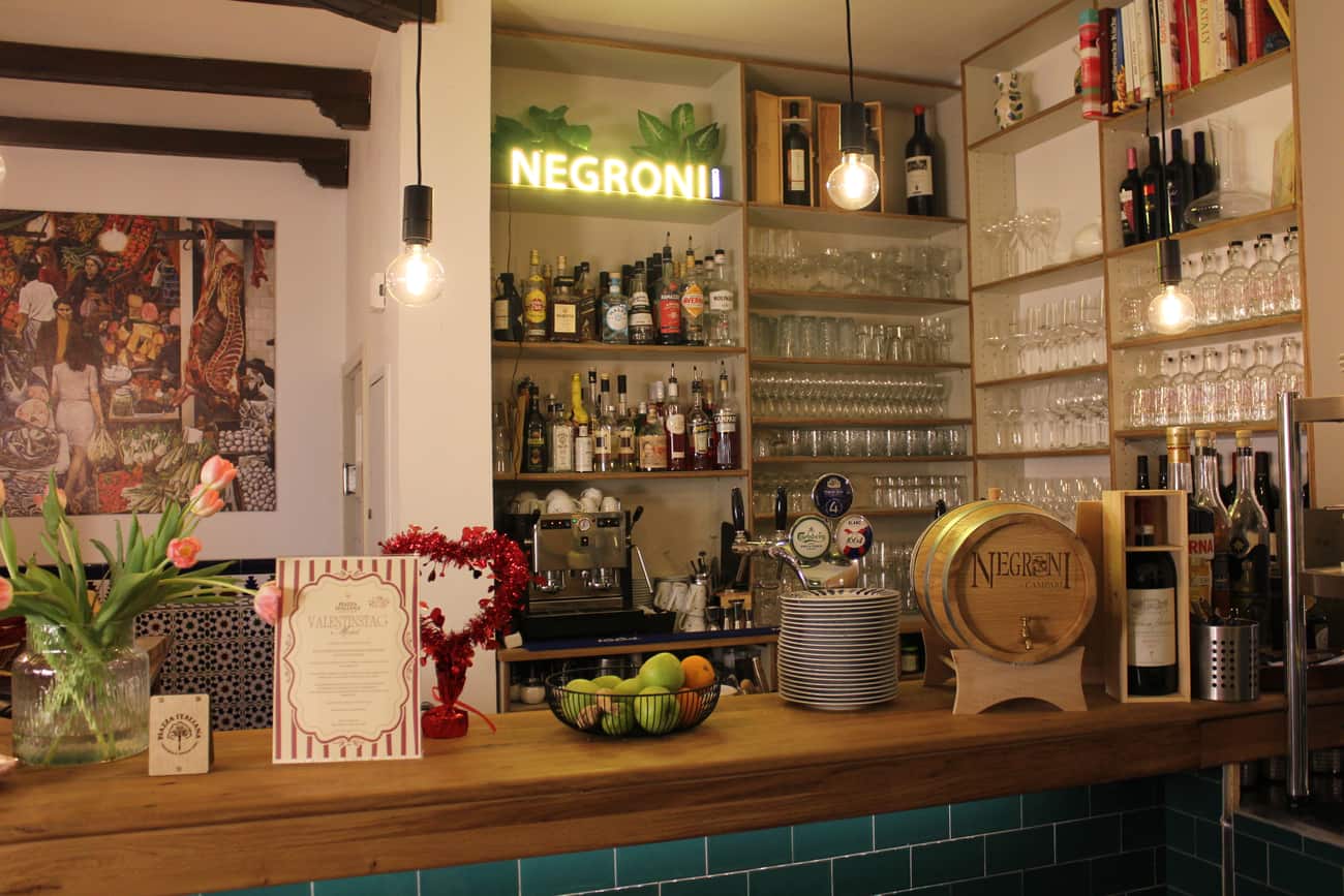 Die grün geflieste Bar der Piazza Italiana mit Negroni-Leuchtschrift