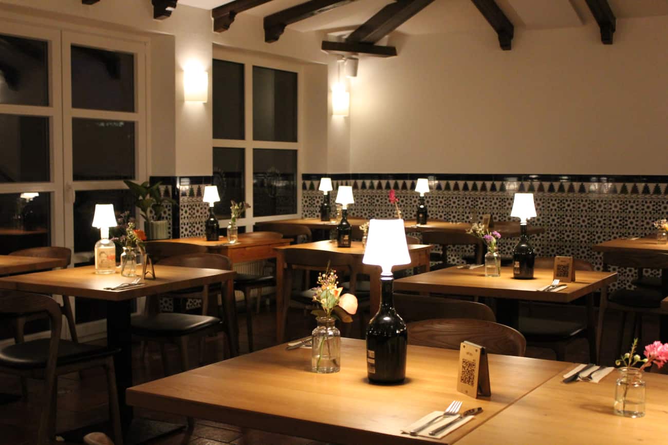 Der Gastraum der Piazza Italiana am Abend mit warmem Licht und Fliesenfries